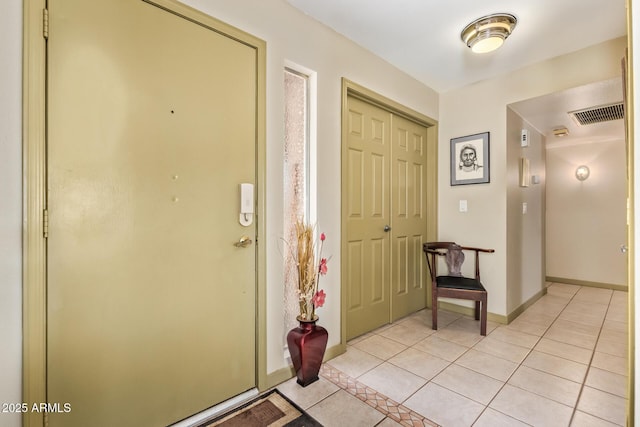 foyer featuring light tile patterned floors, baseboards, and visible vents