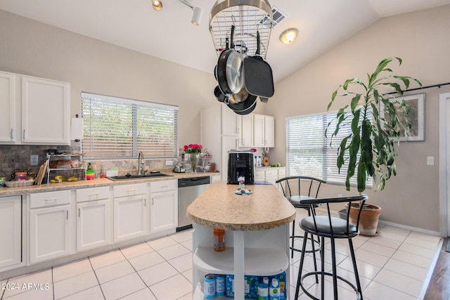 kitchen featuring lofted ceiling, dishwasher, sink, a center island, and white cabinets