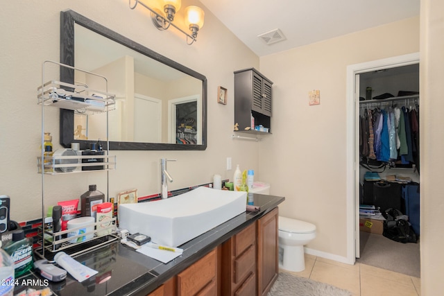 bathroom featuring vanity, toilet, and tile patterned flooring