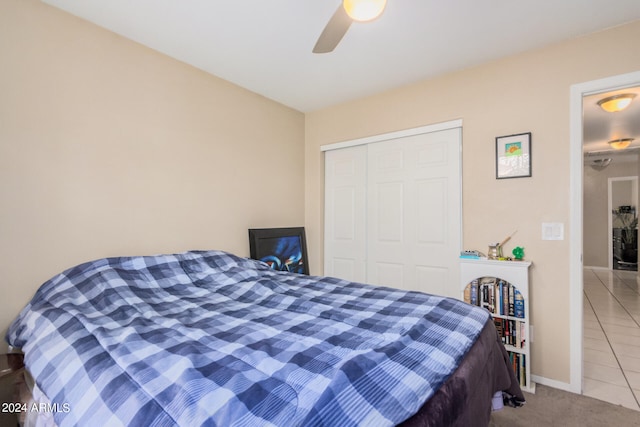 bedroom featuring a closet, light tile patterned flooring, and ceiling fan