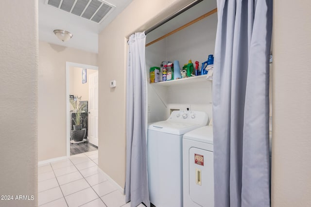 laundry room featuring light tile patterned flooring and washing machine and clothes dryer