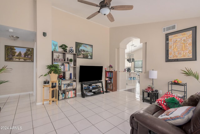 tiled living room with lofted ceiling and ceiling fan