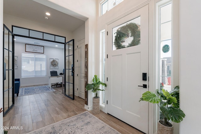 foyer entrance featuring light wood-style flooring, baseboards, and recessed lighting