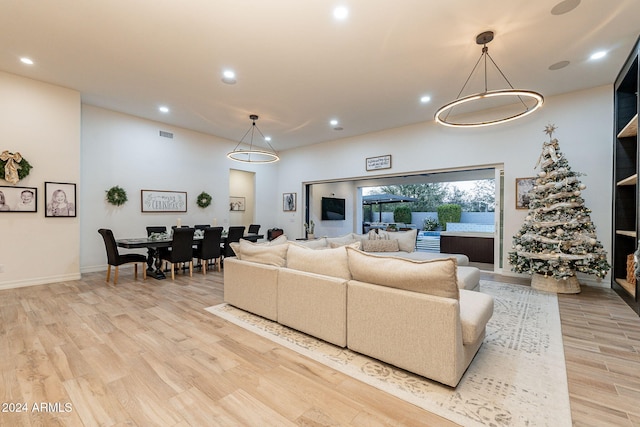 living area with light wood-style floors, visible vents, baseboards, and recessed lighting