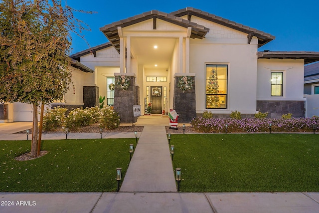 view of front facade featuring a front lawn and stucco siding