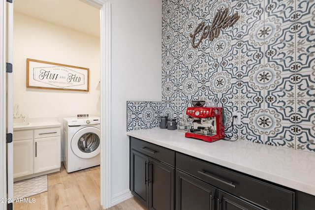 clothes washing area featuring washer / clothes dryer and light wood-style flooring