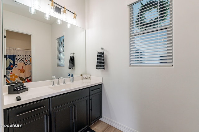 bathroom with vanity, baseboards, and wood finished floors