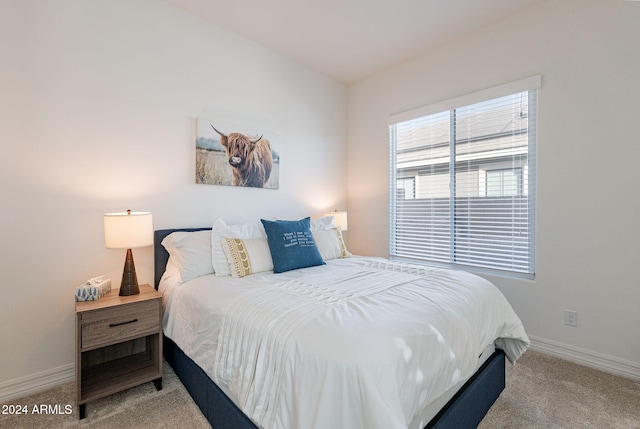 bedroom with baseboards and light colored carpet