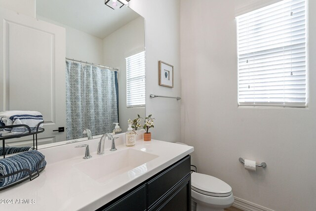 full bathroom featuring vanity, toilet, and baseboards