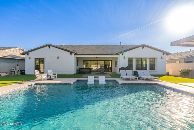 pool with an outdoor hangout area, a patio area, and fence