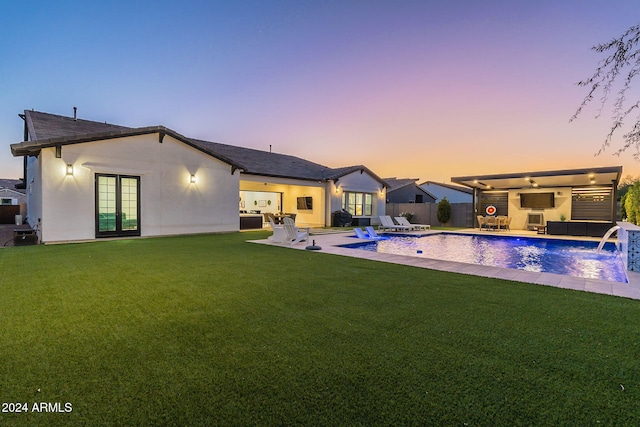 back of property featuring a lawn, a patio area, an outdoor living space, and stucco siding