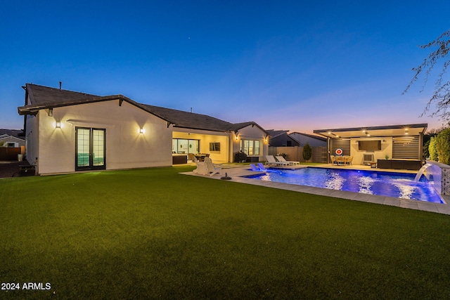 view of pool with a patio area, a jacuzzi, fence, and a yard