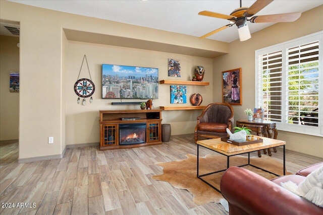 living room with ceiling fan and light hardwood / wood-style flooring