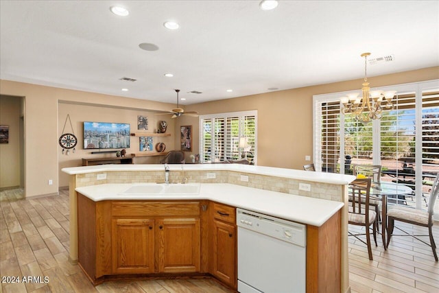 kitchen with sink, white dishwasher, an island with sink, light hardwood / wood-style flooring, and pendant lighting