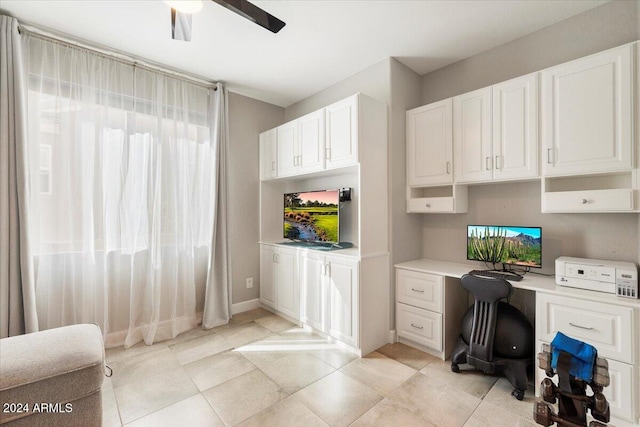 office space with ceiling fan, light tile patterned flooring, and built in desk