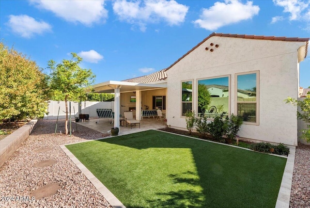 back of property with a yard and a patio