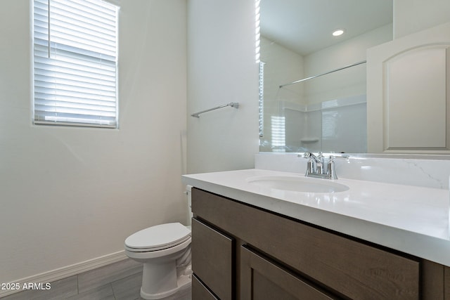 bathroom featuring vanity, toilet, and a shower