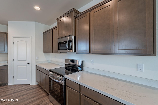 kitchen with light stone counters, dark brown cabinets, stainless steel appliances, and dark hardwood / wood-style floors