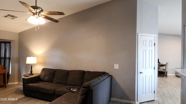 living area featuring visible vents, light wood-style flooring, baseboards, and a ceiling fan