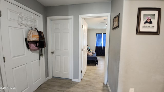 corridor featuring baseboards and wood finish floors