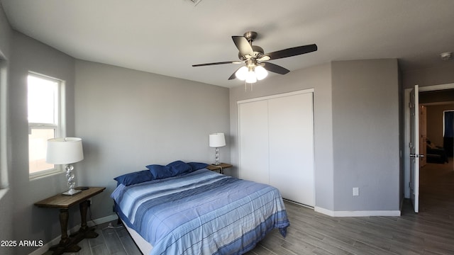 bedroom with ceiling fan, a closet, baseboards, and wood finished floors