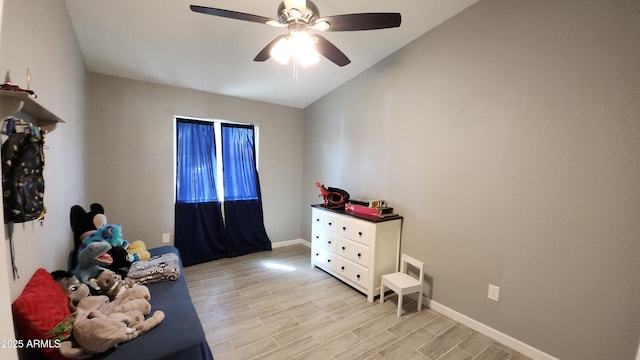 bedroom featuring light wood finished floors, a ceiling fan, lofted ceiling, and baseboards