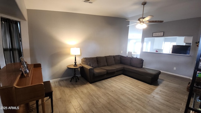 living room featuring visible vents, baseboards, lofted ceiling, wood finished floors, and a ceiling fan