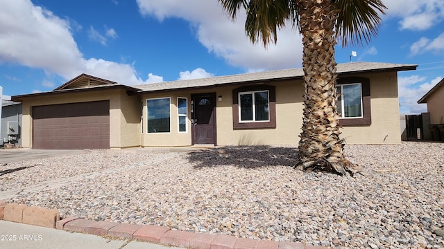 ranch-style house with stucco siding, an attached garage, and driveway