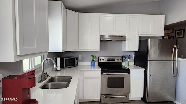 kitchen with under cabinet range hood, white cabinets, stainless steel appliances, and a sink