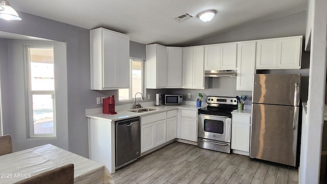 kitchen with visible vents, a sink, light countertops, under cabinet range hood, and appliances with stainless steel finishes