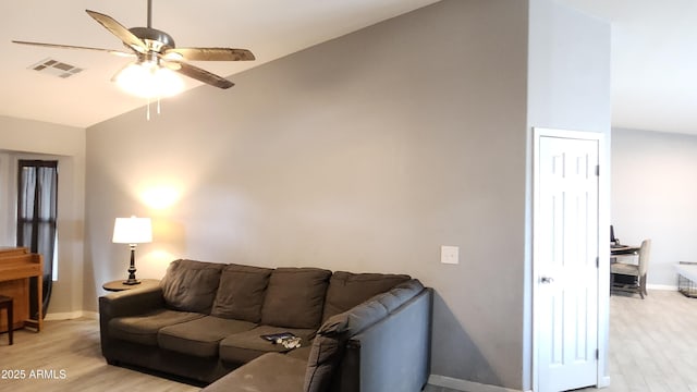 living room featuring visible vents, baseboards, light wood-style floors, and ceiling fan