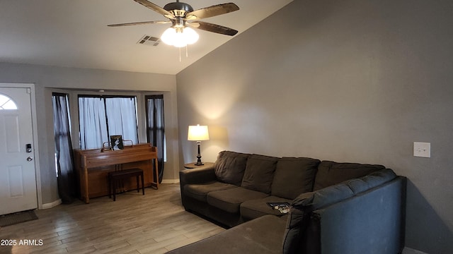 living room featuring baseboards, visible vents, ceiling fan, vaulted ceiling, and light wood-type flooring