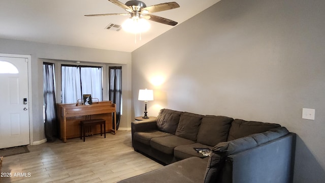 living area featuring visible vents, light wood-style flooring, a ceiling fan, baseboards, and lofted ceiling