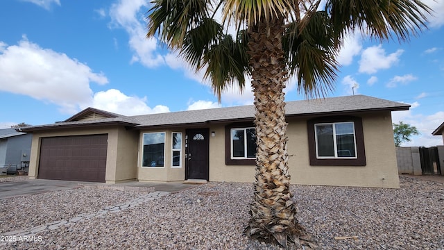 ranch-style house featuring stucco siding, concrete driveway, a garage, and fence