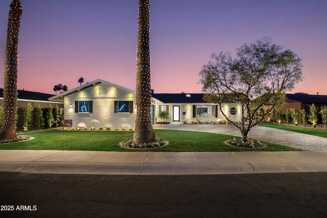 ranch-style home featuring a yard