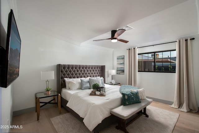 bedroom with ceiling fan, crown molding, and light hardwood / wood-style floors