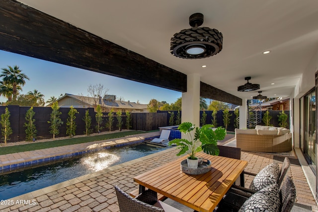 view of patio featuring a swimming pool with hot tub, an outdoor living space, and ceiling fan