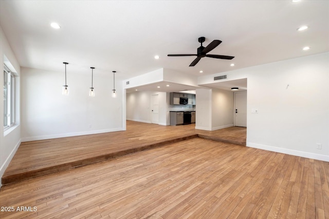 unfurnished living room with light wood-type flooring and ceiling fan