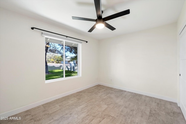 spare room with ceiling fan and light wood-type flooring