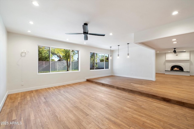 unfurnished living room with ceiling fan and light hardwood / wood-style floors