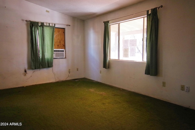 carpeted empty room featuring a textured ceiling and vaulted ceiling