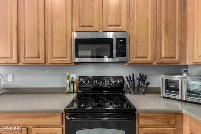 12798 W Dove Wing Way, Peoria, AZ 85383 - kitchen featuring stainless steel microwave, black range with electric stovetop, and light countertops