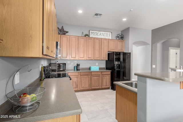 12798 W Dove Wing Way, Peoria, AZ 85383 - kitchen with arched walkways, black refrigerator with ice dispenser, stove, recessed lighting, and stainless steel microwave