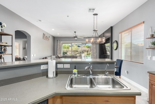 12798 W Dove Wing Way, Peoria, AZ 85383 - kitchen featuring open floor plan, a sink, arched walkways, decorative light fixtures, and a ceiling fan