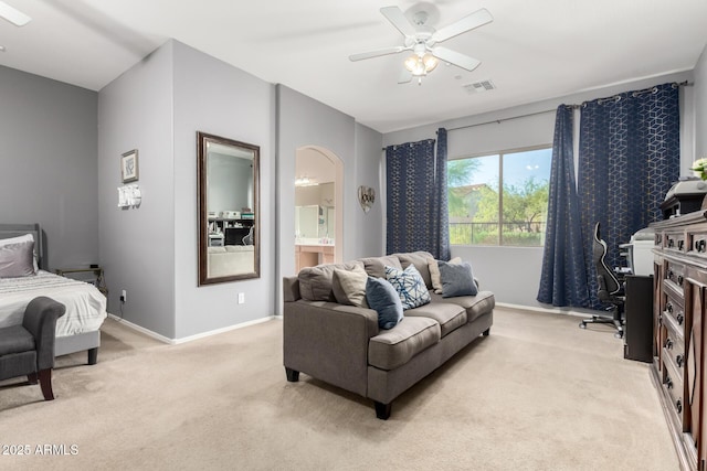 12798 W Dove Wing Way, Peoria, AZ 85383 - living room featuring light colored carpet, baseboards, ceiling fan, and arched walkways