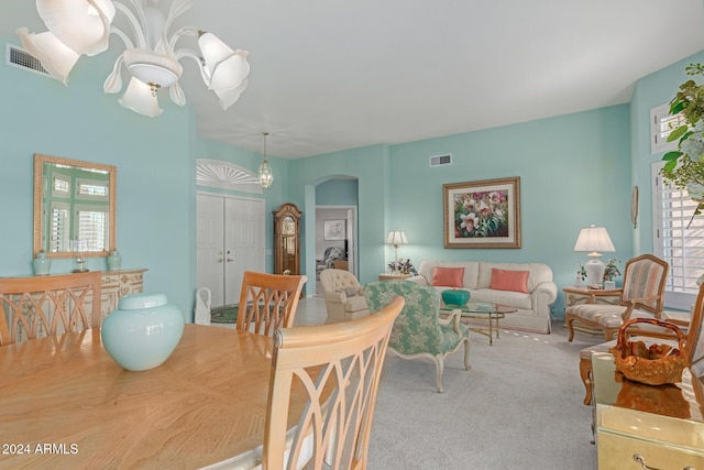 carpeted dining space featuring an inviting chandelier