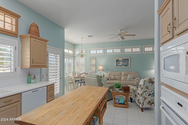 kitchen featuring wood counters, light brown cabinets, white appliances, ceiling fan with notable chandelier, and hanging light fixtures