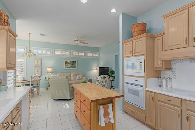 kitchen with light brown cabinetry, ceiling fan with notable chandelier, white appliances, light tile patterned floors, and decorative light fixtures