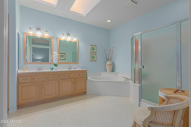 bathroom featuring vanity, a skylight, and separate shower and tub