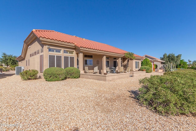 back of property with cooling unit and a patio area